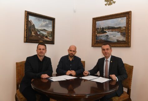 zdjęcie przedstawia siedzącego Rektora PK z przedstawicielami firmy EX7